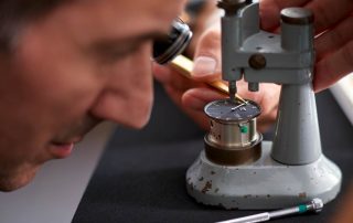 Walter Hess arbeitet an einem Zifferblatt.