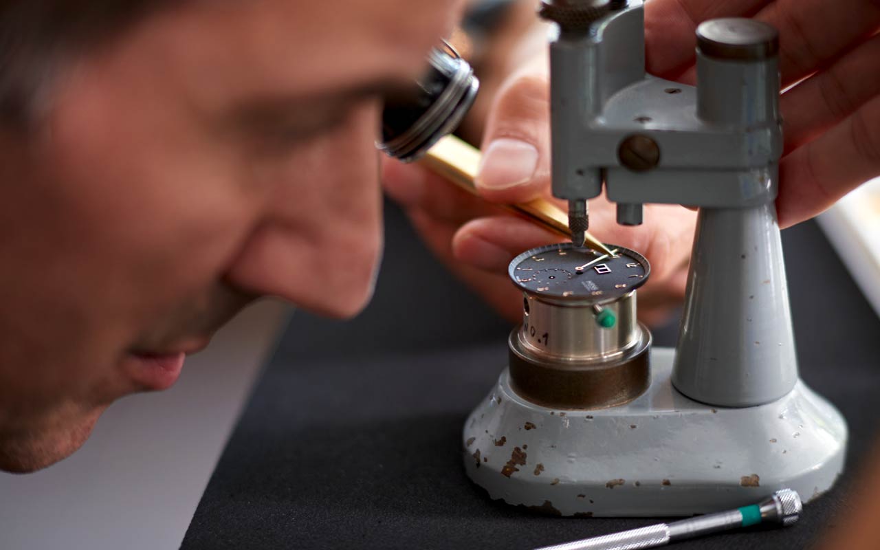 Walter Hess arbeitet an einem Zifferblatt.