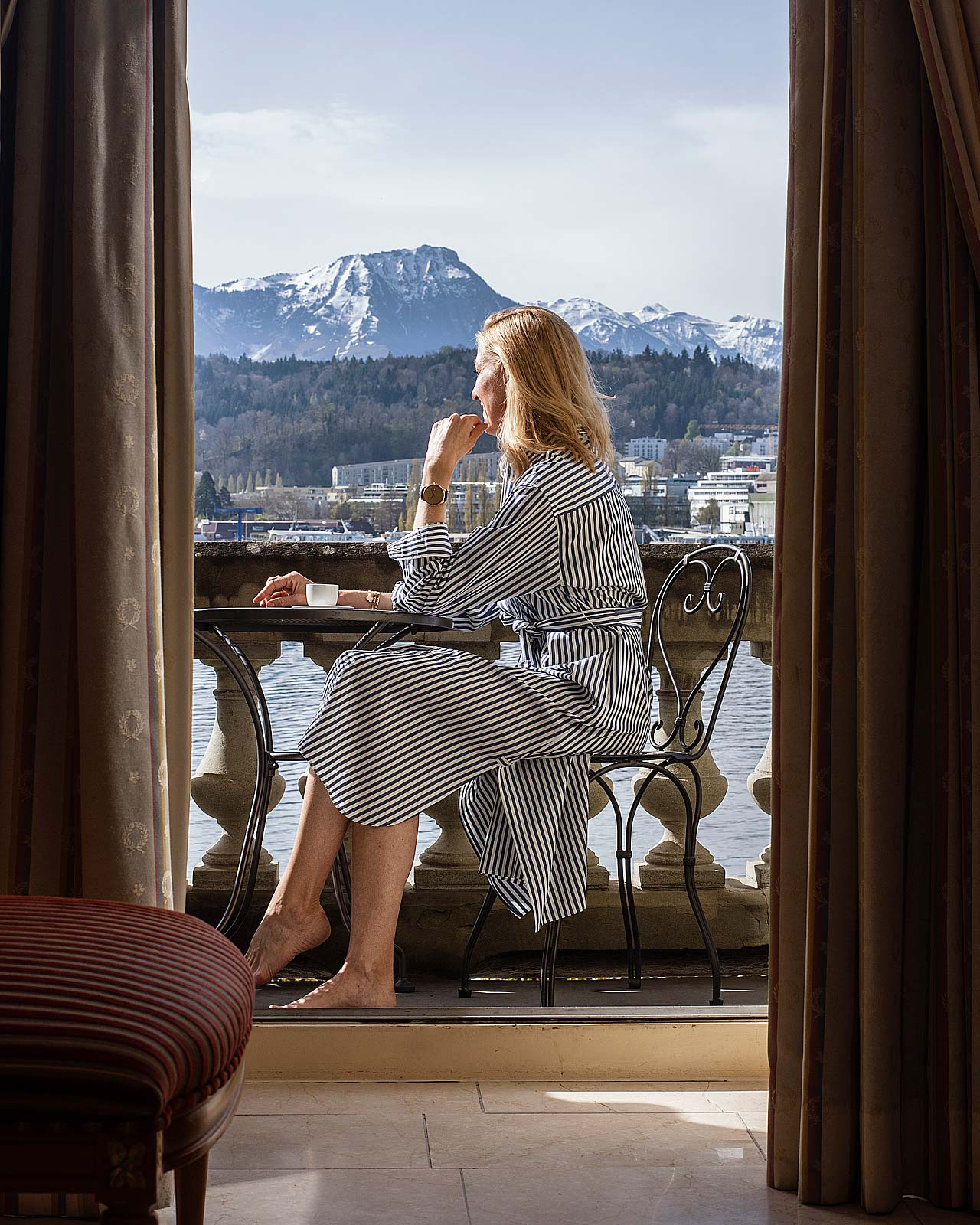 Eine Frau sitzt auf dem Balkon des Grand Hotel Luzern.