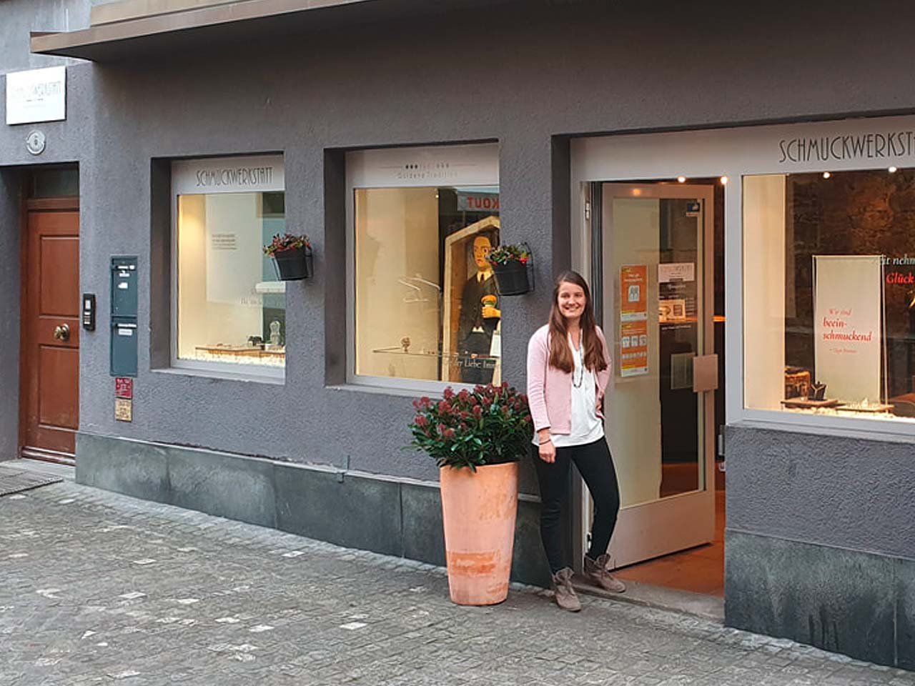 Eine Frau steht vor der Schmuckwerkstatt in Luzern.